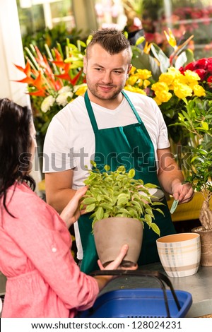 Smiling male florist selling potted plant flower shop market woman