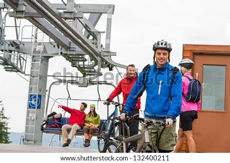 Sporty couple getting on bicycles after chair lift trip