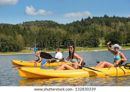 Friends enjoying summertime kayaking on river holiday free time