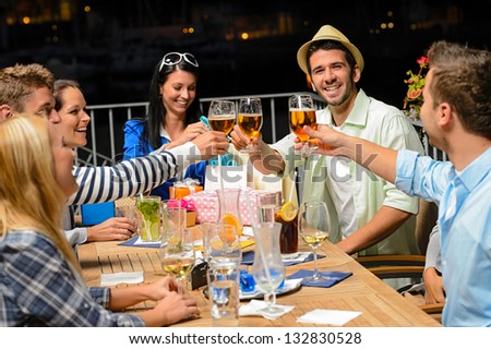 Group of young friends drinking beer outdoors terrace night out