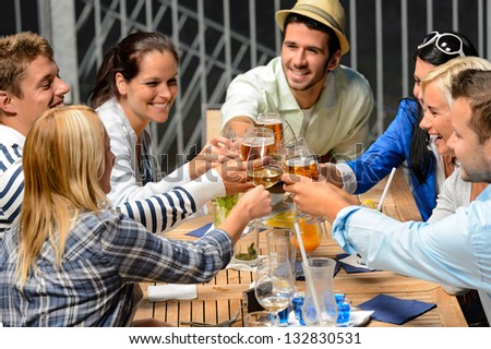Group Of Cheerful Young People Toasting With Drinks Night Out