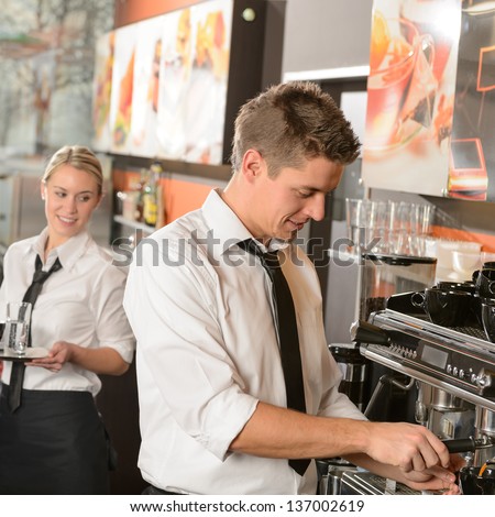 Young waiter and waitress working in bar serving coffee