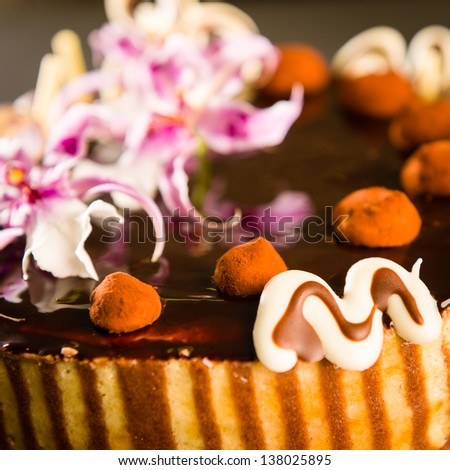 Richly decorated cake with chocolate coating and truffles on top