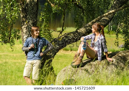 Happy hikers resting couple laughing at each other in the nature