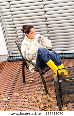 Young woman sitting drinking cup tea patio fall relaxing