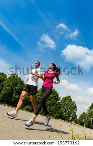 Low angle view of  happy couple running outdoors