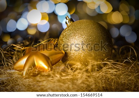 Gold christmas bauble and star decoration on dark lights background