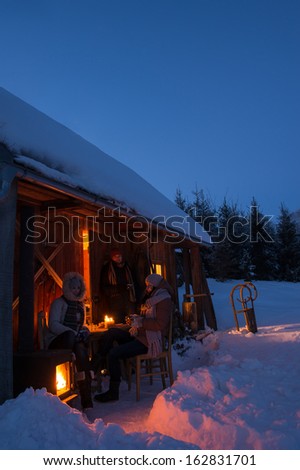 Sunset winter cottage friends enjoying evening in snow countryside