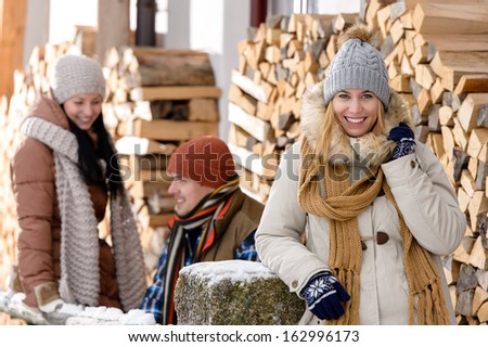 Young people outside winter cottage wooden logs countryside