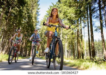 Group of friends on bicycles in countryside enjoy summer sport