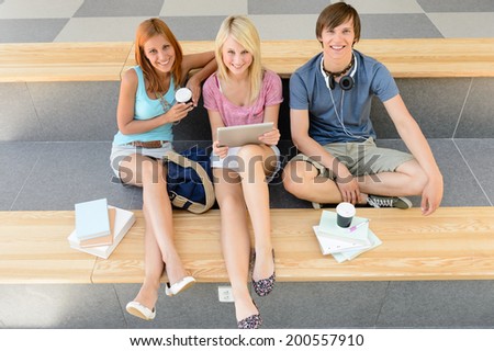 College student friends relax during break with tablet and books