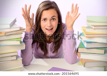 Desperate student girl sitting between stack of books purple background
