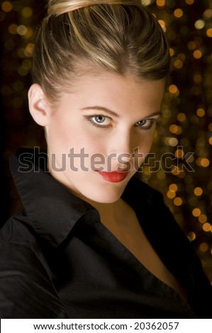 Gorgeous woman in black shirt in front of out of focus Christmas lights