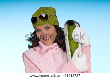 Fashion model wearing green and pink winter clothes on blue background