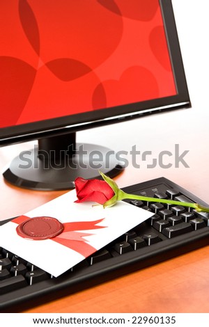 Computer screen and Valentine card with rose on keyboard