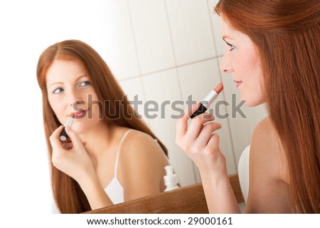 Red Hair Lipstick. stock photo : Body care - Beautiful red hair woman applying lipstick in the