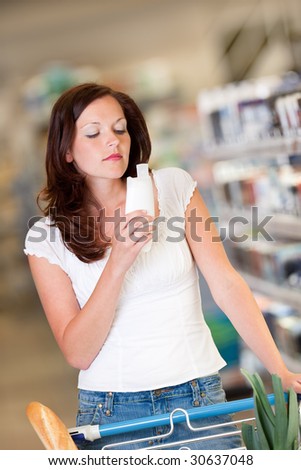 Shopping series - Beautiful brunette smelling shampoo in a shopping mall