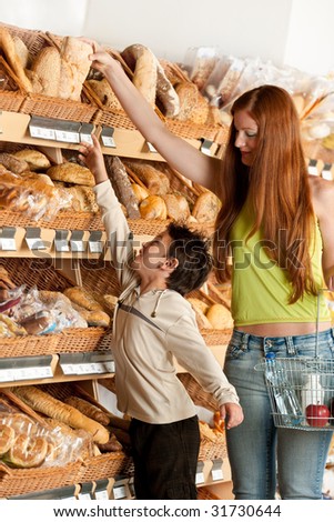 Grocery store -  Red hair woman and child choosing bread in a supermarket