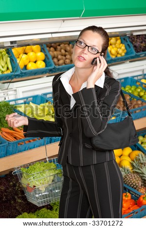 Grocery store - Business woman with mobile phone holding shopping basket