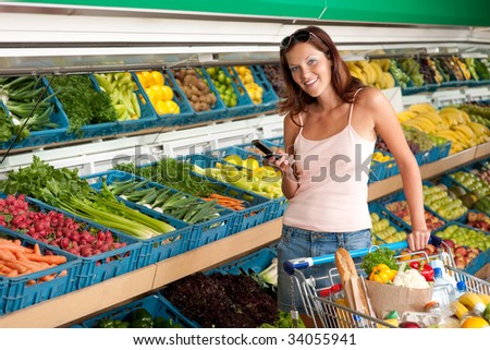 Grocery store - Young woman with mobile phone in a supermarket