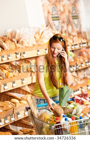Grocery store: Red hair woman with mobile phone and shopping cart
