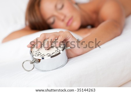 Woman holding silver alarm clock, shallow DOF