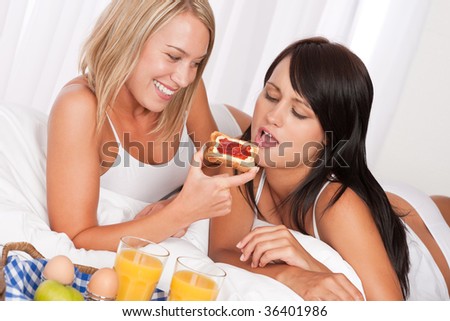 stock photo Two young women having home made breakfast in bed lesbian 