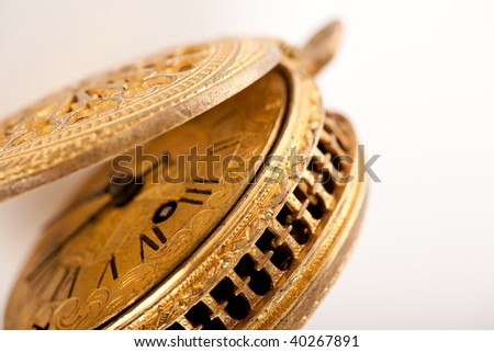 Close-up of antique yellow brass pocket watch isolated on white, macro lens