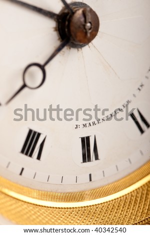 Close-up of antique white and gold clock with Roman numeral, macro lens