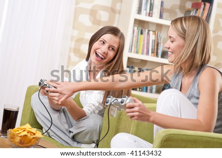Students - Two happy female teenager playing TV game and having fun