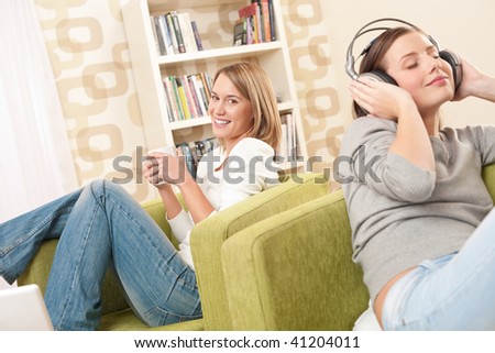Students - Two female teenager relaxing in lounge having coffee and listening to music