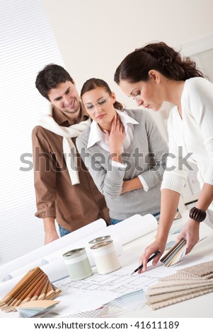 Female interior designer with two clients at office choosing colors