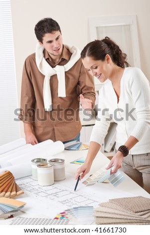 Two interior designer working at office with color swatch and can of paint