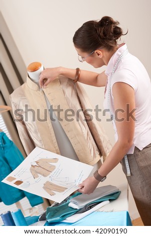 Female tailor working with fashion mannequin at studio