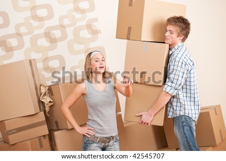 Moving house: Man and woman with box in new home