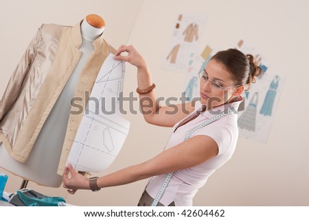 Female fashion designer working with pattern cutting at studio