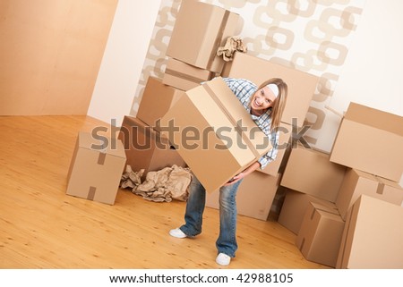 Moving house: Woman holding big carton box in new home