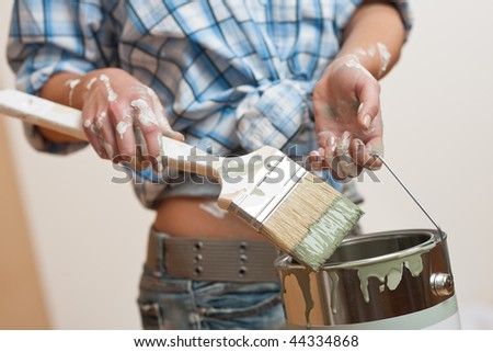 Home improvement: Woman holding paint brush and paint can