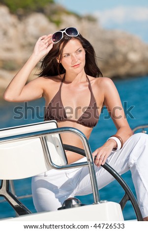 Young woman sailing on luxury yacht sunbathing in bikini
