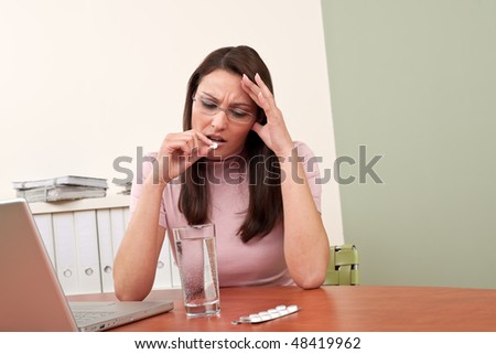 Businesswoman with headache take pill at office