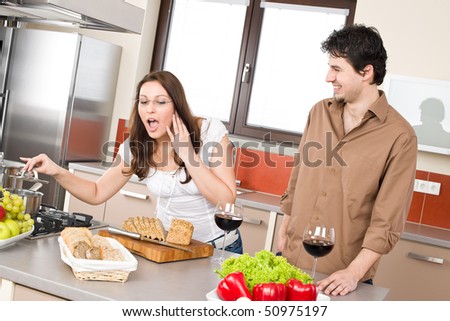 Cooking - happy couple in modern kitchen cook together