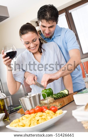 Happy couple cut vegetables in kitchen, cook together