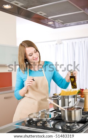 Cooking - Young woman with spaghetti on stove cooking Italian cousine