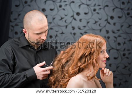 stock photo : Professional hairdresser with long red curly hair fashion model at black luxury salon