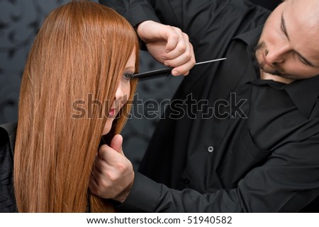 Professional hairdresser with long red hair fashion model at luxury salon, comb hair