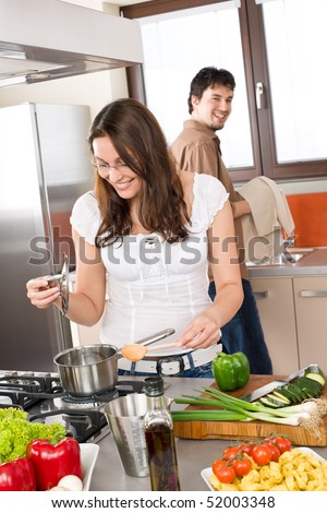 Young couple cook in modern kitchen, man helping with dishes