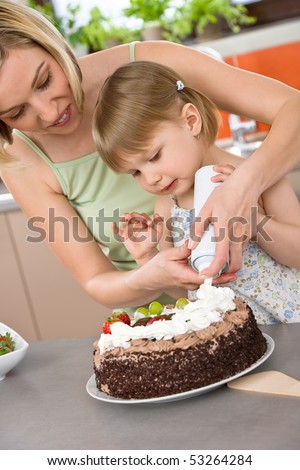 Mother and child with chocolate cake in modern kitchen