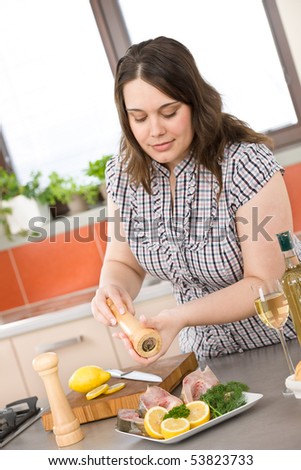 Cook - plus size woman prepare fish with white wine and bread in modern kitchen