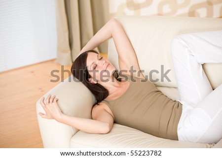 Beautiful woman lying down sleeping on sofa in living room