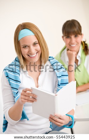 Student at home - two young woman study together with book